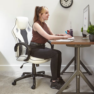 x rocker pc office gaming chair in white and black in a home office setting with female model sat on the chair